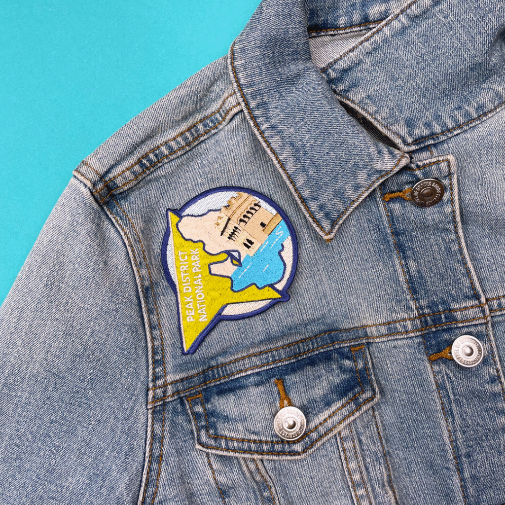 Blue denim jacket with chest patch: Palo District National Park, wildlife scene, turquoise background.