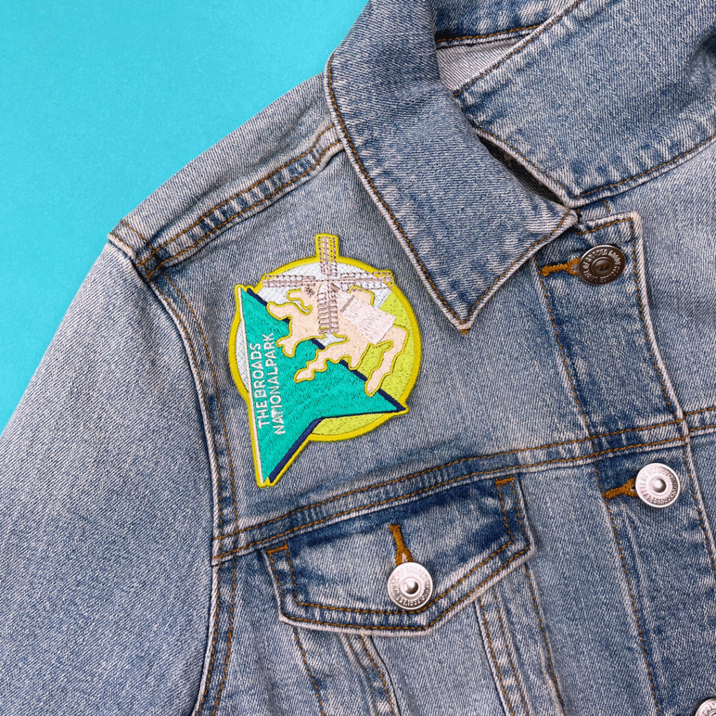 Blue denim jacket with chest patch: green triangle, map outline, THE BROADS NATIONAL PARK.