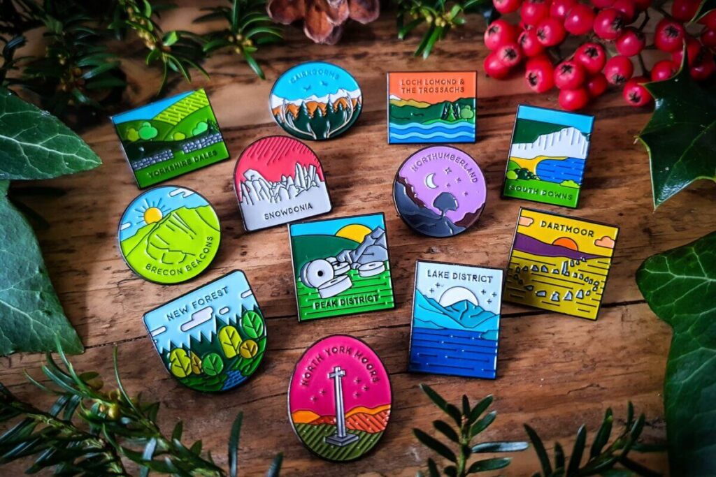 Colorful pins of UK national parks with landscapes like Lake District & Dartmoor, greenery, berries.